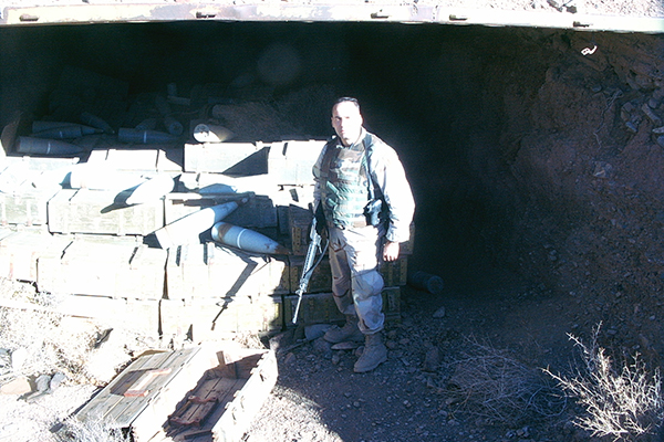 A man standing in front of a pile of bricks.