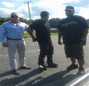 Three men standing in a parking lot