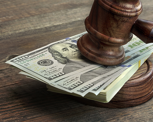 A judge 's gavel on top of money.